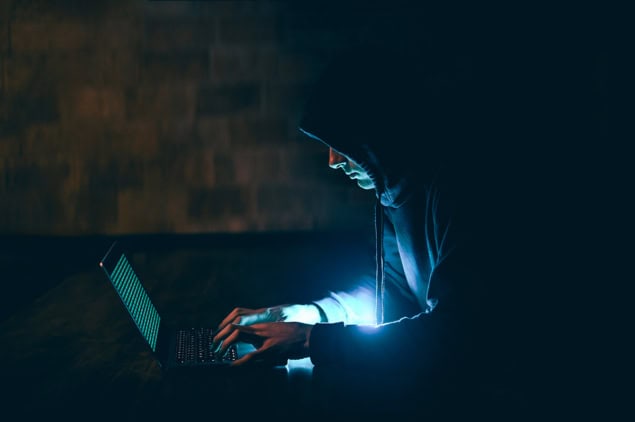 Hacker at a computer in the dark Hacker at a computer in the dark