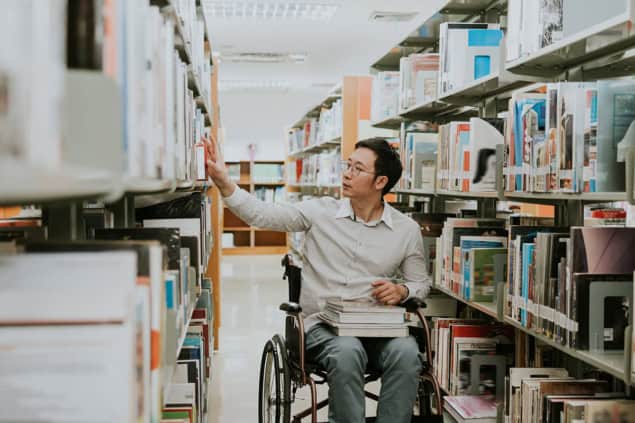 Person in wheelchair in a library Person in wheelchair in a library