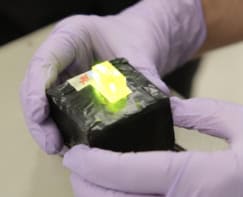 A physicist holding a nuclear photovoltaic battery