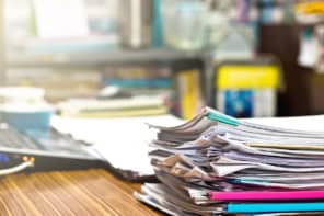 Pile of unfinished paperwork on an academic's desk