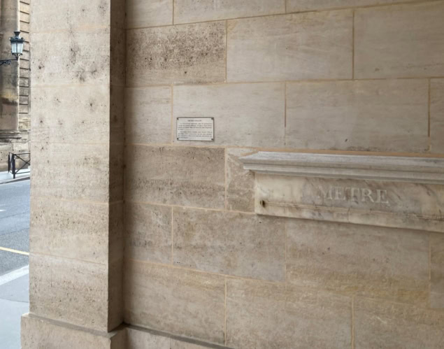 Paris metre standard Photo of a metre-long measure made from marble and embedded in the stone wall of a building in Paris. A small plaque to the left of the metre is inscribed with the words