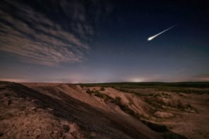 Meteor falling to earth over a desert landscape