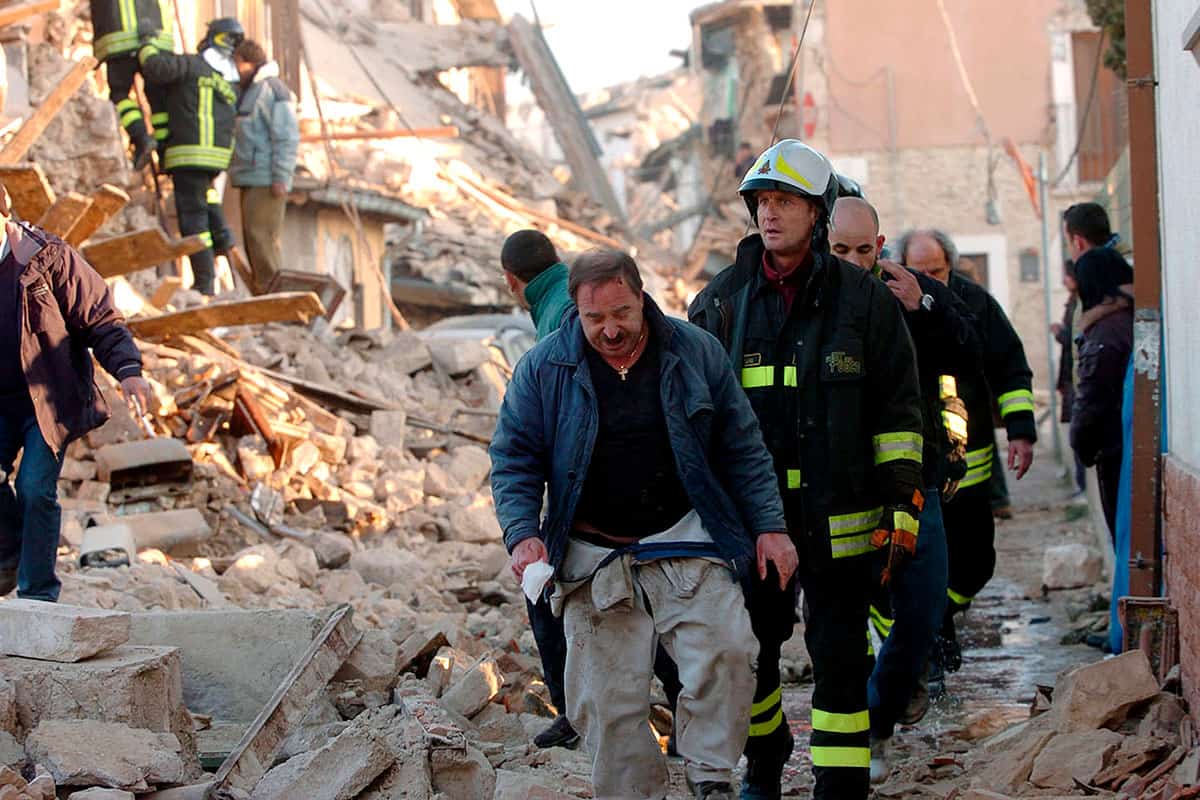 Several rescue workers in the rubble of collapsed buildings