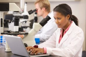 Scientists using microscopes and computers