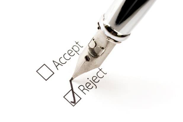 Ink pen ticking a box labelled "reject"