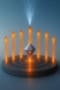 Illustration showing photon emission from a nanodiamond being directed by a bullseye antenna. The bullseye antenna is shown flat, and seven parallel orange arrows representing photons emerge from different parts of the bullseye, like candles on a birthday cake. At the centre of the bullseye is a diamond
