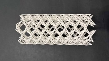 Image of the 3D printed kagome tube, which is white and features a repeating structure