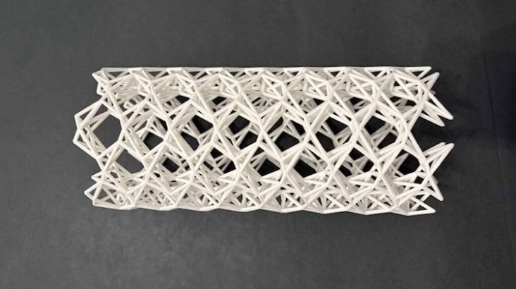Image of the 3D printed kagome tube, which is white and features a repeating structure