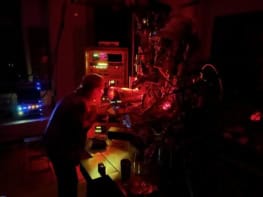 A person in a laboratory suffused with dim red light