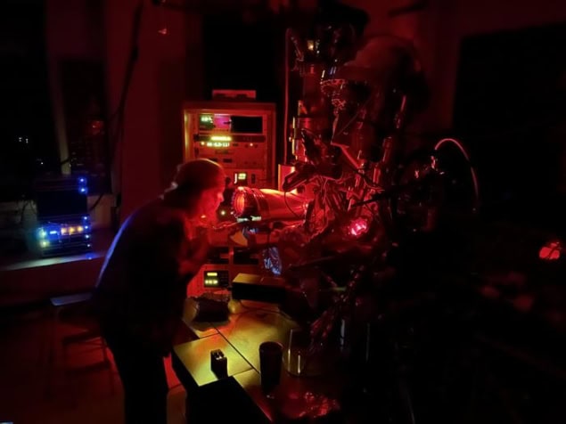 A person in a laboratory suffused with dim red light