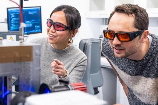 Two researchers with goggles in their lab