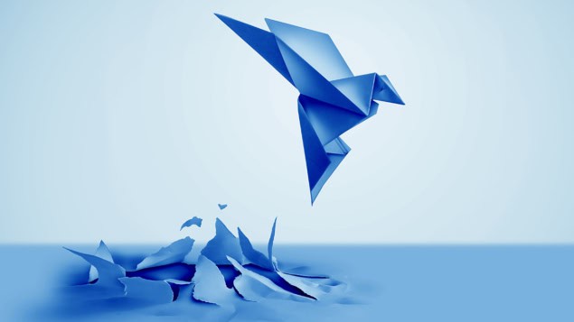 Blue paper origami bird emerging from the paper sheet