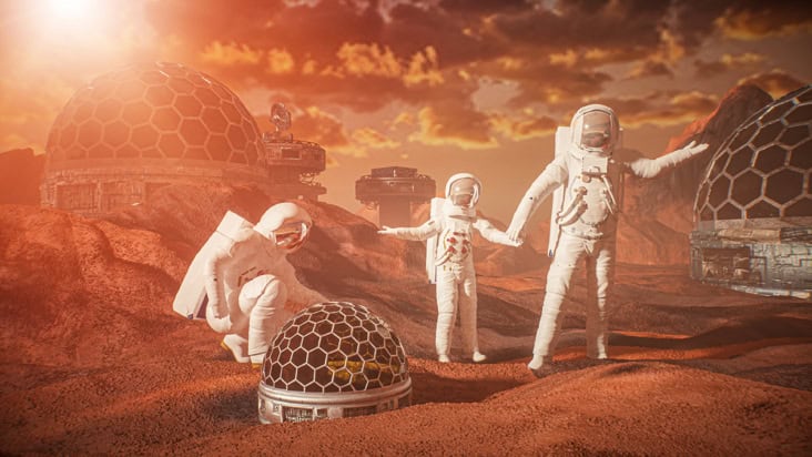 Two adults and a child wearing spacesuits on a red planet with biodomes in the background