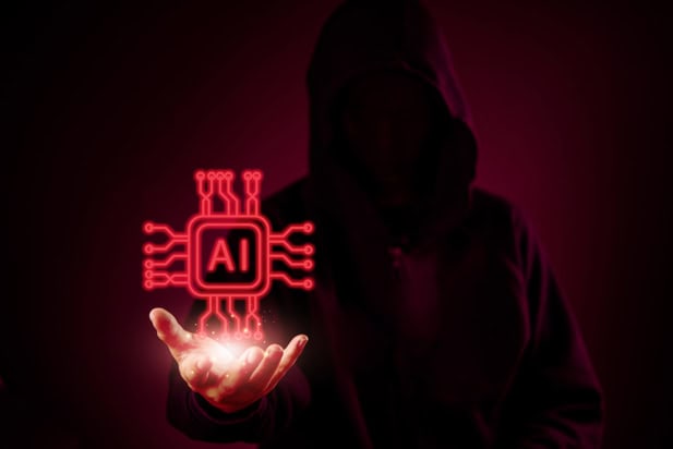 silhouette of figure in a hoodie holding a glowing red AI chip