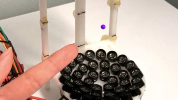 Photograph of a particle being help in acoustic tweezers