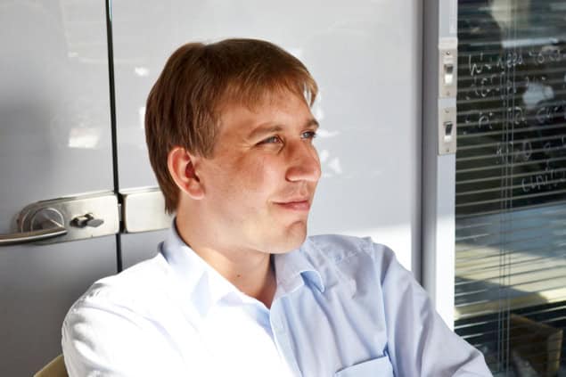 A smiling man in sunlight looking off into the distance