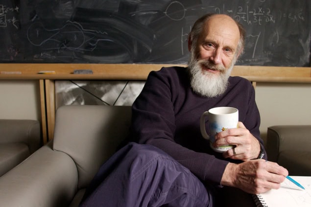 An older man with a beard sitting on a couch