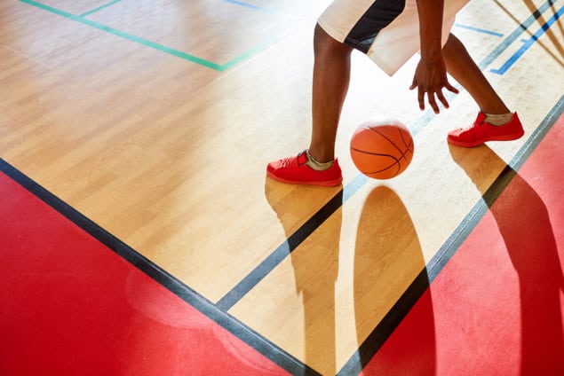 Basketball player on court dribbling a ball
