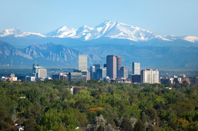 Aerial photo of downtown Denver, Colorado, with the Rocky Mountains beyond