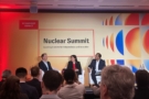 Photo of Charles Oppenheimer, Najat Mokhtar and Vijay Vaitheeswaran on stage at the Nuclear Summit in London. They're all wearing business suits and several rows of heads are in the foreground