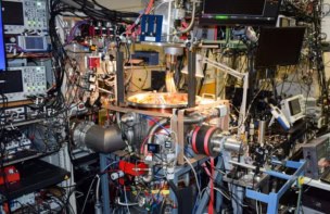 Photo of the experimental equipment used to measure the proton charge radius. There's a vacuum system at the centre of the photo, but it's almost completely hidden under cables, wires, monitors and other instruments.