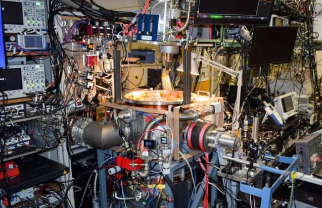 Photo of the experimental equipment used to measure the proton charge radius. There's a vacuum system at the centre of the photo, but it's almost completely hidden under cables, wires, monitors and other instruments.