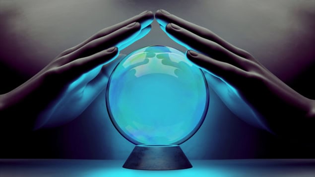 A pair of male hands surrounding a crystal ball