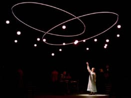 Isis Hainsworth on stage under interlocking rings and many small lights