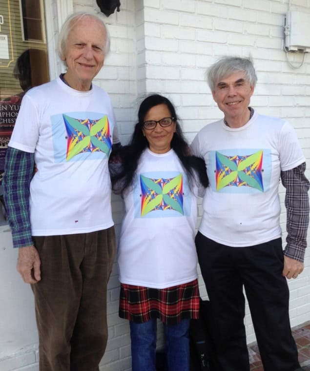 Three people wearing matching T-shirts with colourful Hofstadter's butterfly artwork
