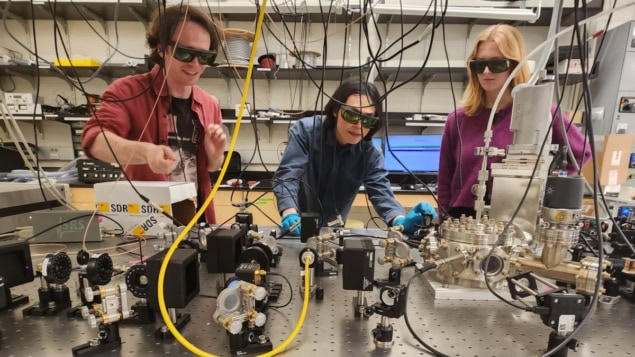 Photo of three researchers with the Yale experiment